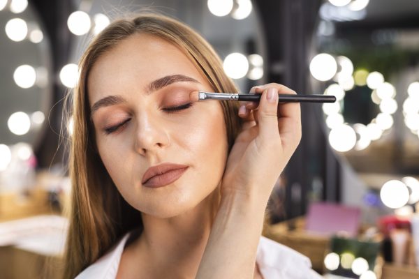 close-up-make-up-artist-applying-eyeshadow-woman-with-brush